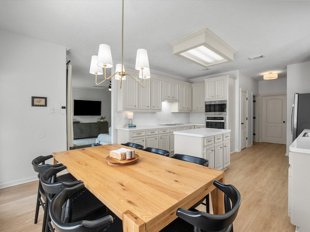 dining room with light wood-style flooring, baseboards, and a chandelier