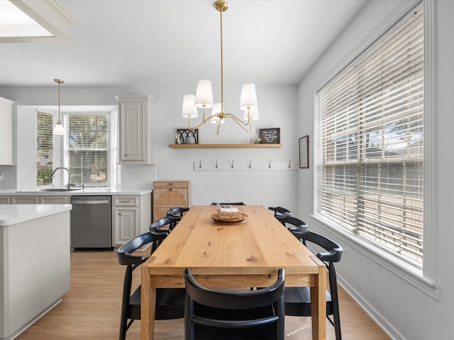 dining space featuring plenty of natural light, light wood-type flooring, and a chandelier