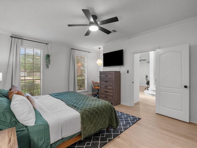 bedroom with light wood-style floors, ornamental molding, ceiling fan, and baseboards