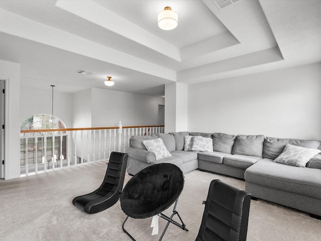 living room with carpet floors and a tray ceiling