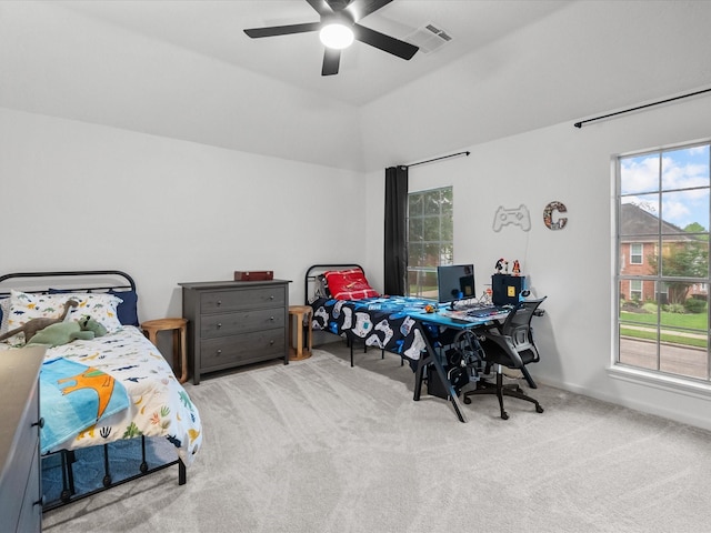 carpeted bedroom featuring multiple windows, ceiling fan, vaulted ceiling, and an office area