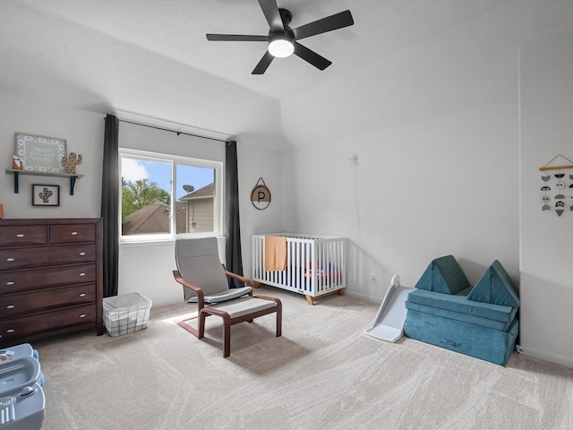 bedroom with carpet floors, a nursery area, ceiling fan, and lofted ceiling