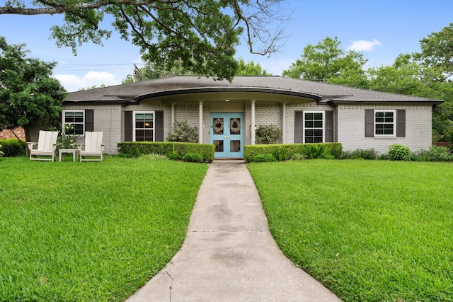 single story home featuring french doors, brick siding, and a front yard