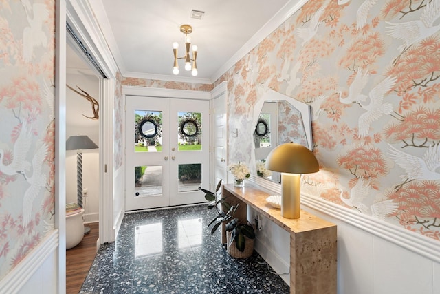 entryway featuring a chandelier, crown molding, french doors, and wallpapered walls