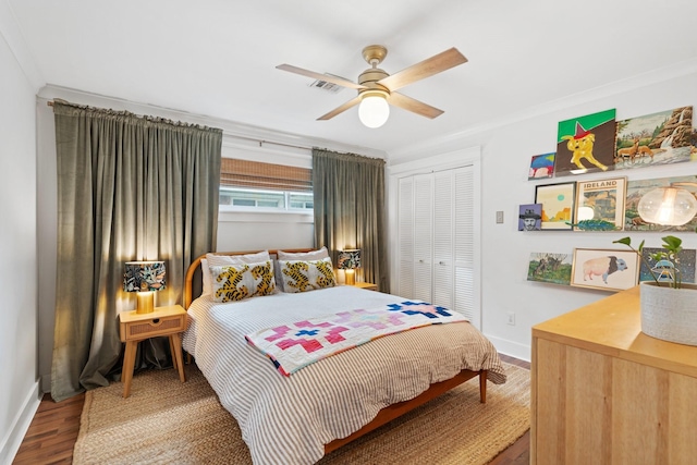 bedroom featuring a closet, baseboards, wood finished floors, ceiling fan, and ornamental molding