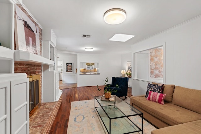 living area featuring dark wood finished floors, a skylight, and crown molding