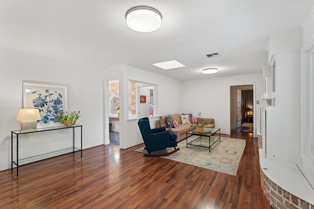 living room with wood finished floors and a skylight