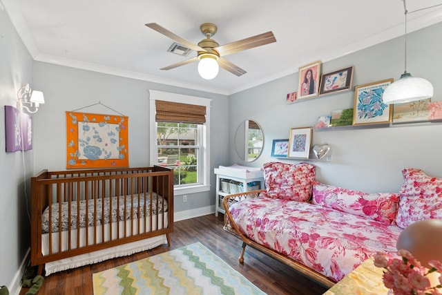 bedroom with wood finished floors, crown molding, baseboards, and a ceiling fan
