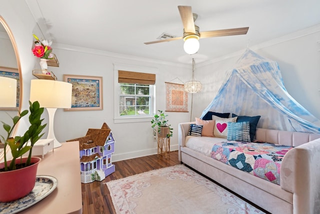 bedroom featuring wood finished floors, crown molding, baseboards, and a ceiling fan
