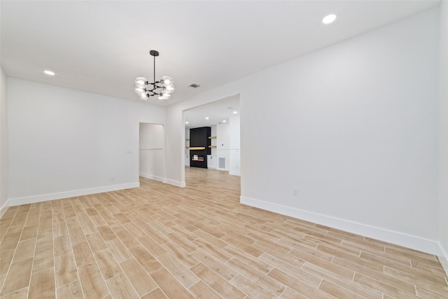 1003 Kelley St, Houston, TX 77009 - empty room with a chandelier, light wood finished floors, baseboards, and recessed lighting