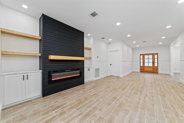 1003 Kelley St, Houston, TX 77009 - unfurnished living room featuring a large fireplace, light wood finished floors, baseboards, recessed lighting, and french doors