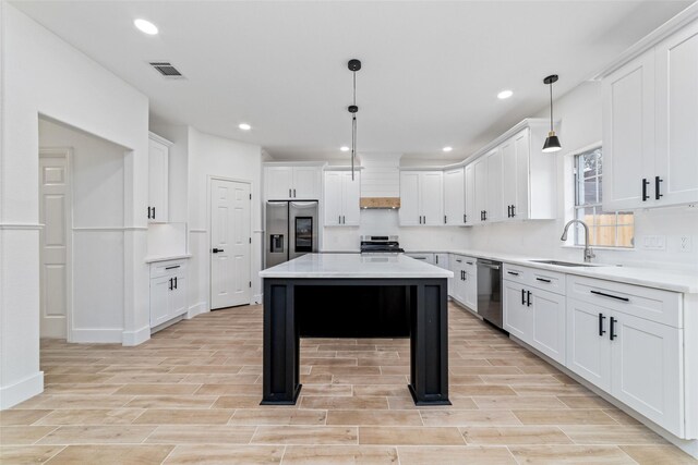 1003 Kelley St, Houston, TX 77009 - kitchen with appliances with stainless steel finishes, a sink, light wood-type flooring, white cabinets, and light countertops