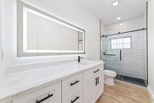 1003 Kelley St, Houston, TX 77009 - bathroom featuring toilet, vanity, a marble finish shower, wood tiled floors, and recessed lighting