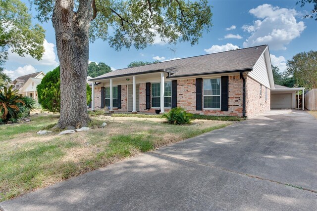 ranch-style home with brick siding, a front lawn, and a shingled roof