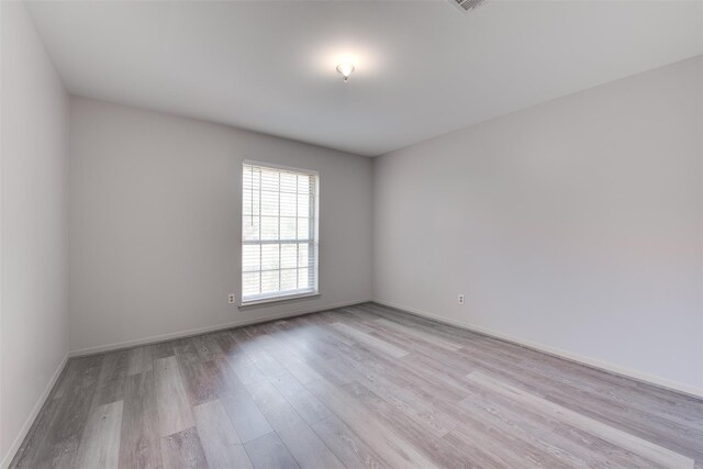 spare room with light wood-style flooring and baseboards
