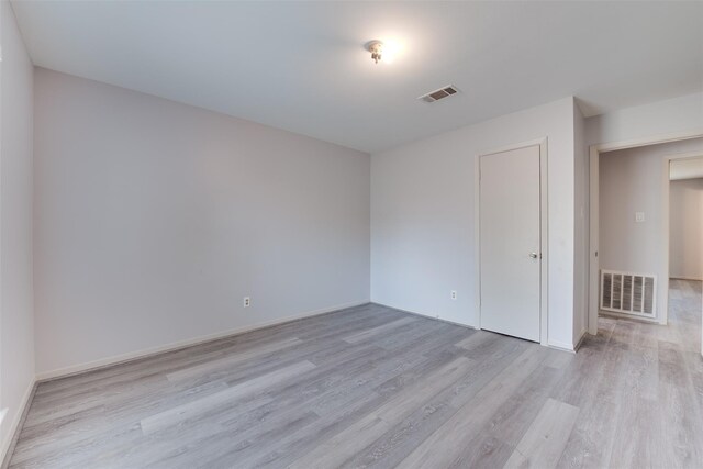 unfurnished room with light wood-type flooring and baseboards