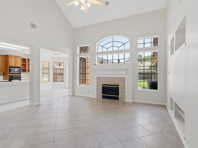 23334 Fairbranch Dr, Katy, TX 77494 - unfurnished living room featuring a ceiling fan, high vaulted ceiling, light tile patterned floors, a tiled fireplace, and baseboards
