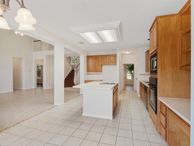 23334 Fairbranch Dr, Katy, TX 77494 - kitchen with light tile patterned floors, light countertops, black appliances, and a kitchen island with sink