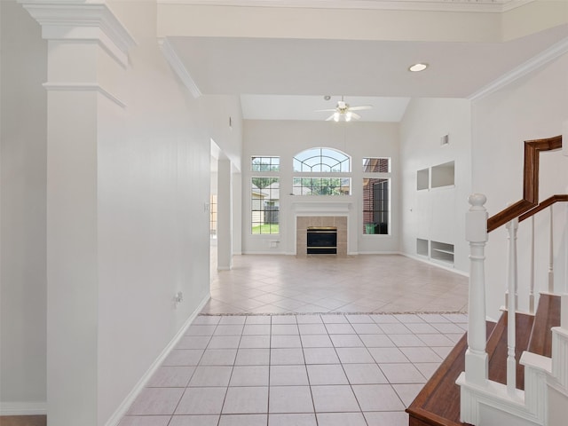 23334 Fairbranch Dr, Katy, TX 77494 - unfurnished living room featuring light tile patterned floors, ceiling fan, a tile fireplace, stairs, and baseboards