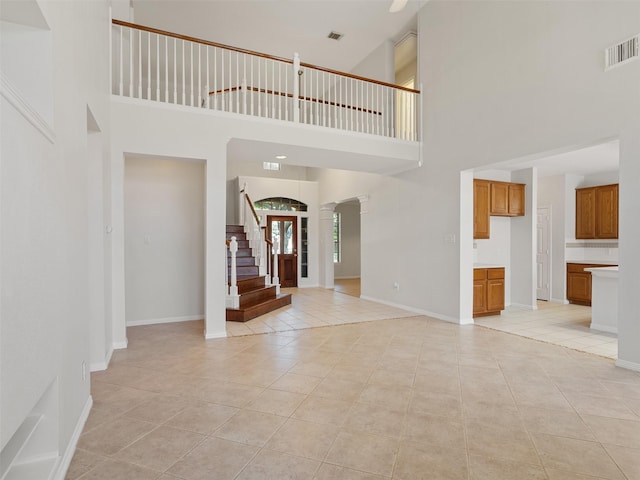 23334 Fairbranch Dr, Katy, TX 77494 - foyer entrance with a high ceiling, light tile patterned floors, stairs, and baseboards