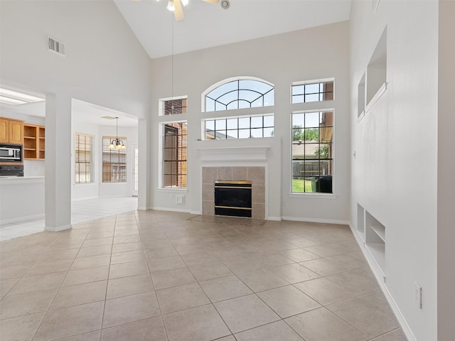 23334 Fairbranch Dr, Katy, TX 77494 - unfurnished living room featuring light tile patterned flooring, high vaulted ceiling, a fireplace, built in shelves, and a ceiling fan