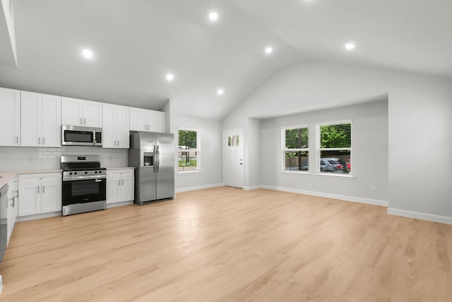 kitchen with stainless steel appliances, white cabinets, light countertops, lofted ceiling, and recessed lighting