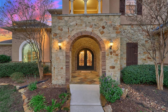 entrance to property with stone siding and french doors