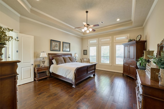 bedroom with a tray ceiling, dark wood-style flooring, ornamental molding, baseboards, and a ceiling fan