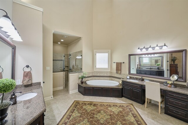 full bath featuring tiled shower, a garden tub, two vanities, tile patterned flooring, and a towering ceiling