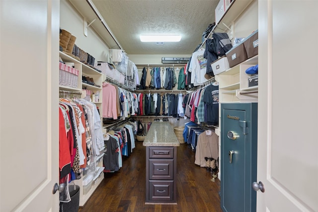 walk in closet with dark wood-type flooring