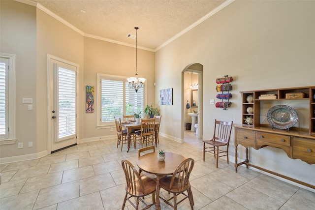 dining area with arched walkways, a textured ceiling, light tile patterned floors, a chandelier, and ornamental molding