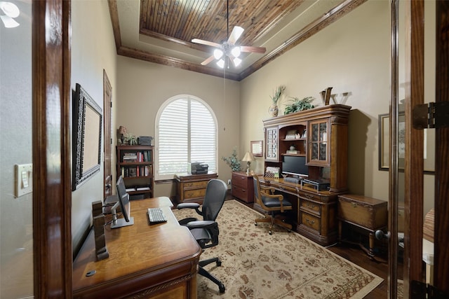 office space featuring ceiling fan, wood finished floors, crown molding, wooden ceiling, and a raised ceiling