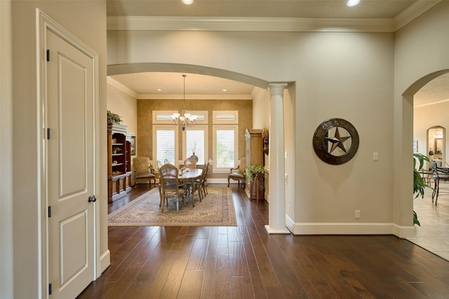 dining room featuring baseboards, dark wood-style flooring, arched walkways, and crown molding
