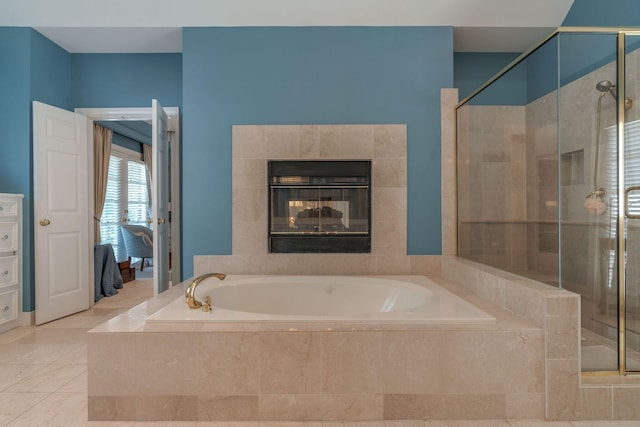 full bathroom featuring a shower stall, a bath, ensuite bathroom, a tiled fireplace, and tile patterned flooring