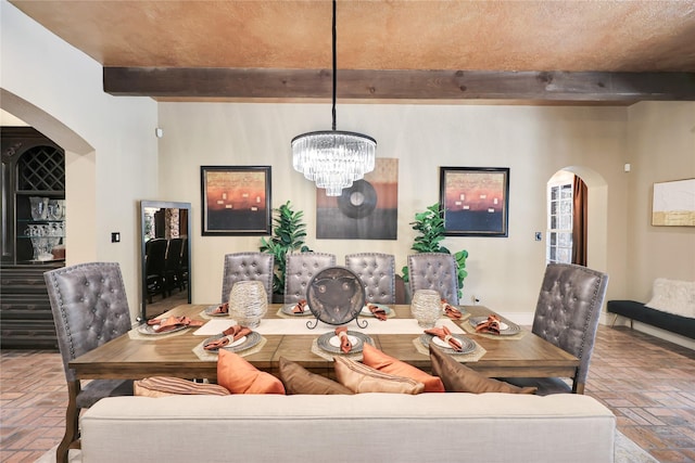13315 Timberwild Ct, Tomball, TX 77375 - dining space with arched walkways, beam ceiling, brick flooring, and a chandelier