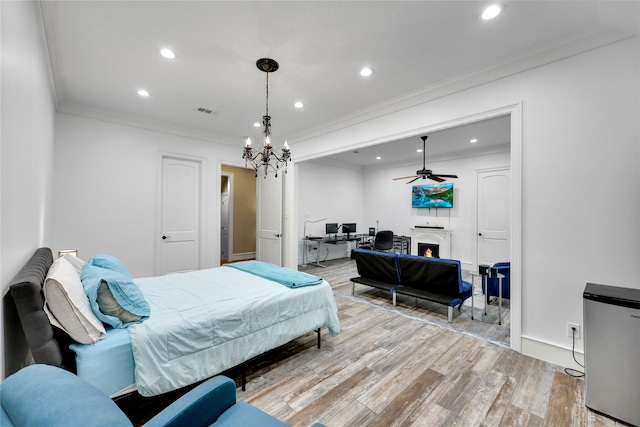 13315 Timberwild Ct, Tomball, TX 77375 - bedroom with ornamental molding, light wood-style floors, recessed lighting, a chandelier, and a warm lit fireplace