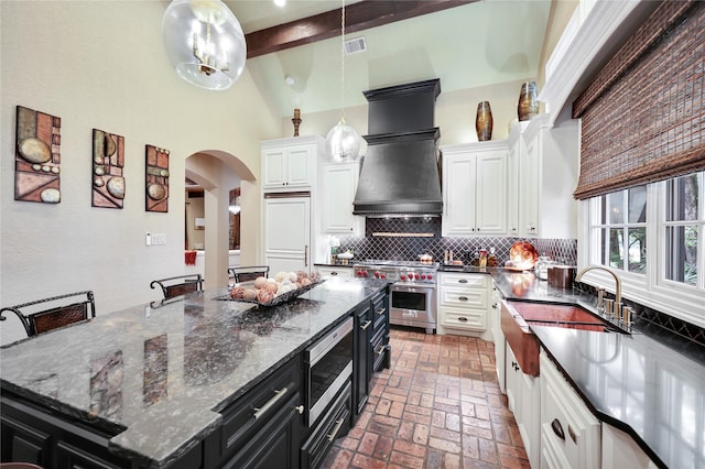 13315 Timberwild Ct, Tomball, TX 77375 - kitchen featuring dark cabinetry, built in appliances, white cabinetry, backsplash, and high vaulted ceiling
