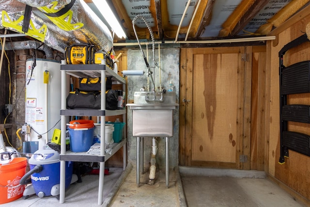 storage room with gas water heater and a sink