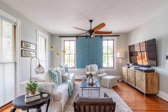 living area with wood finished floors, ceiling fan, and baseboards