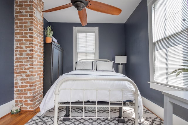 bedroom featuring wood finished floors, baseboards, and a ceiling fan