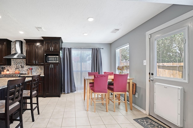 dining area featuring light tile patterned floors, recessed lighting, and baseboards