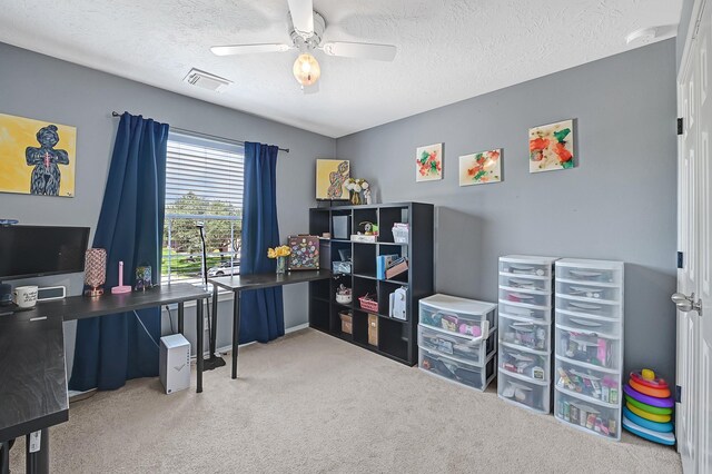 carpeted home office with ceiling fan and a textured ceiling