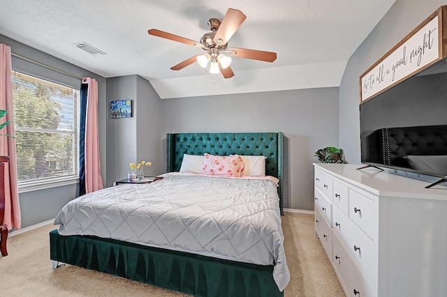 bedroom with light colored carpet, vaulted ceiling, baseboards, ceiling fan, and a textured ceiling