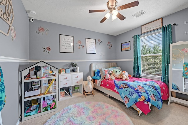 carpeted bedroom featuring ceiling fan and a textured ceiling