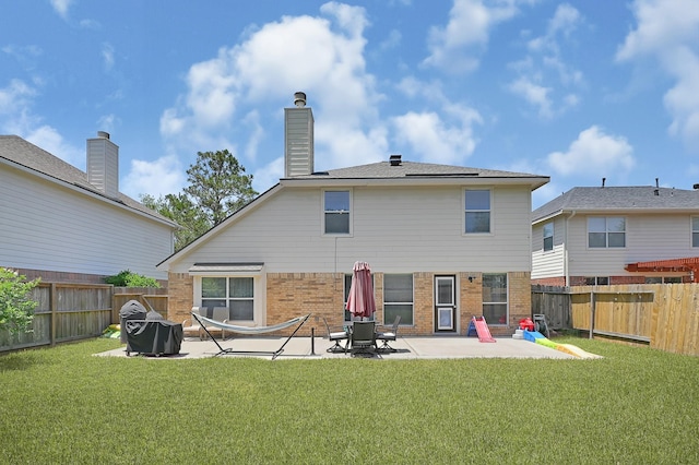 rear view of house with brick siding and a patio