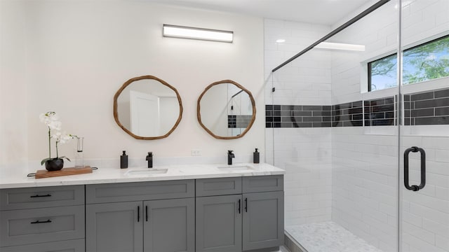 full bathroom featuring a shower stall and double vanity