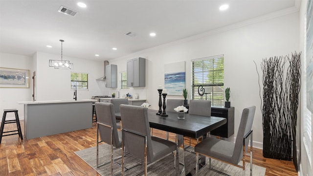 dining area featuring recessed lighting, light wood-type flooring, crown molding, a chandelier, and baseboards