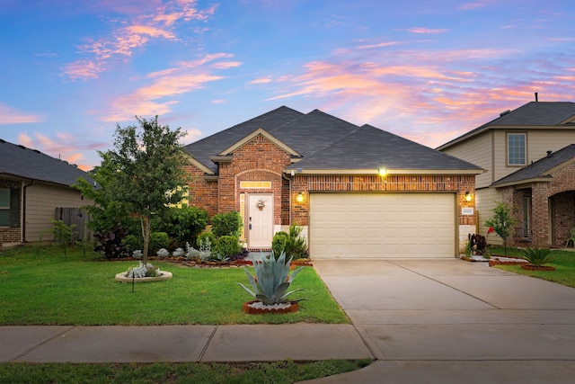 view of front of property with brick siding, concrete driveway, a garage, a lawn, and roof with shingles