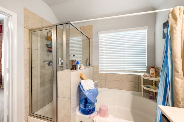 full bath with a shower stall, vaulted ceiling, and a bath