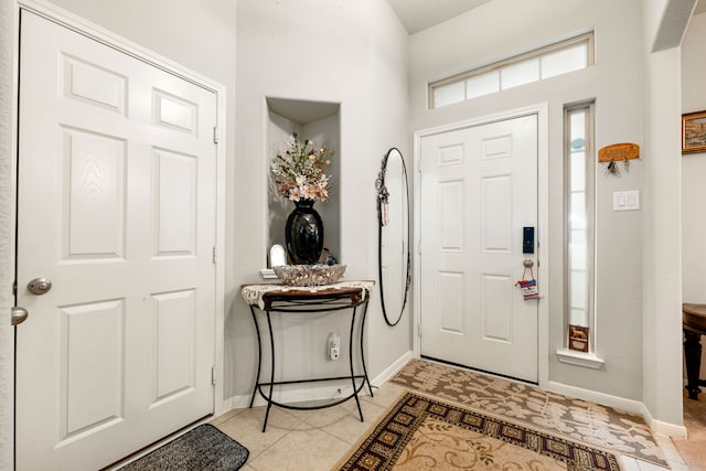 entryway featuring baseboards and light tile patterned flooring